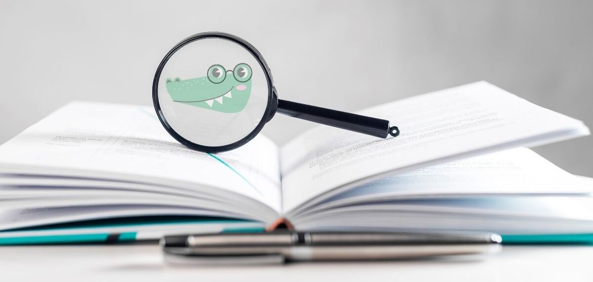 Close-up of hands writing an academic essay with textbooks and pen