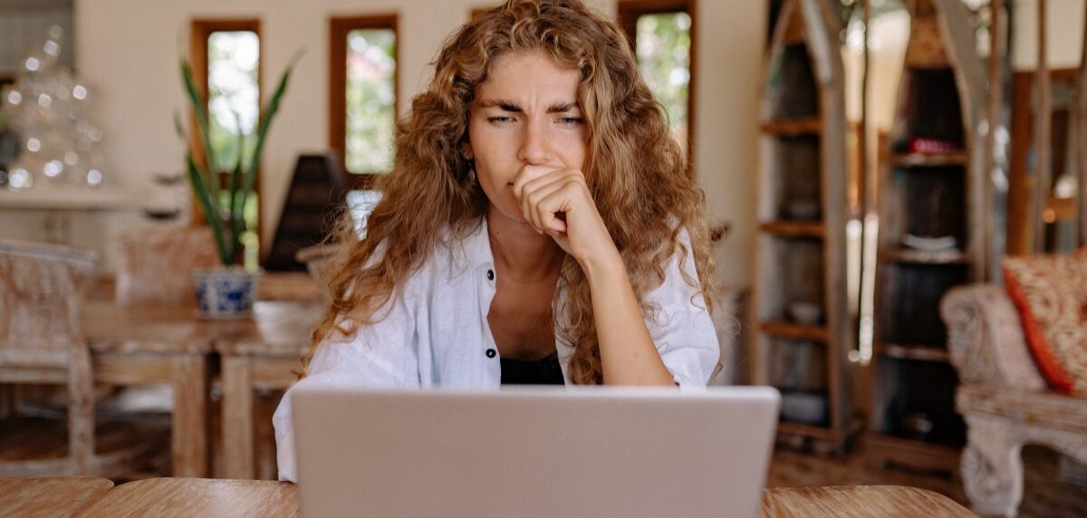 Frustrated job seeker looking at laptop with multiple job applications and rejection emails on screen